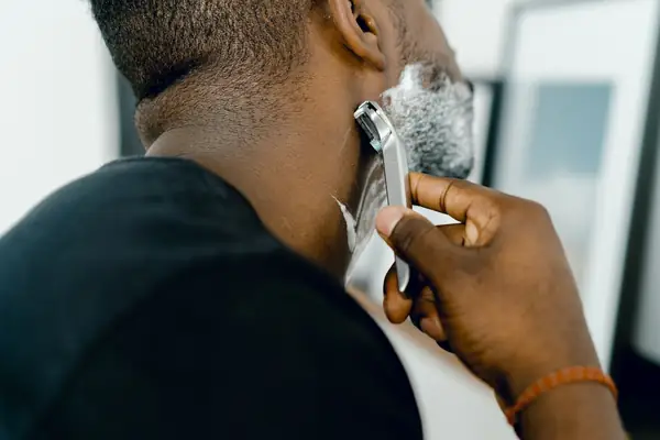 Homem fazendo a barba com aparelho de lâmina